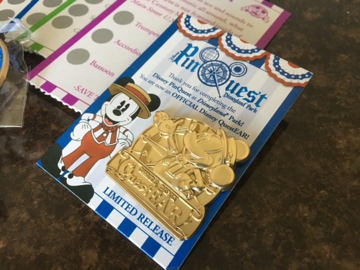 After completing your quest, you can BUY this pin as a reward. It's super cute, but after spending $75, they couldn't throw this in?